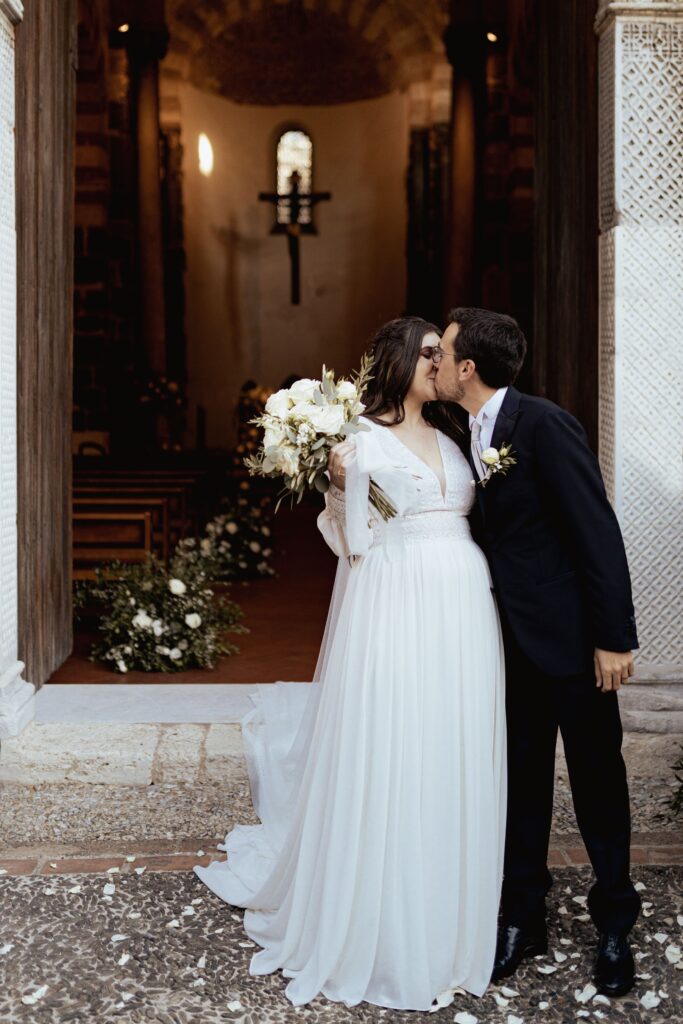 Nyforlovet par foran en historisk italiensk kirke – en vakker feiring av kjærlighet og drømmebryllup i Italia. Foto: Anna O. Brambilla.