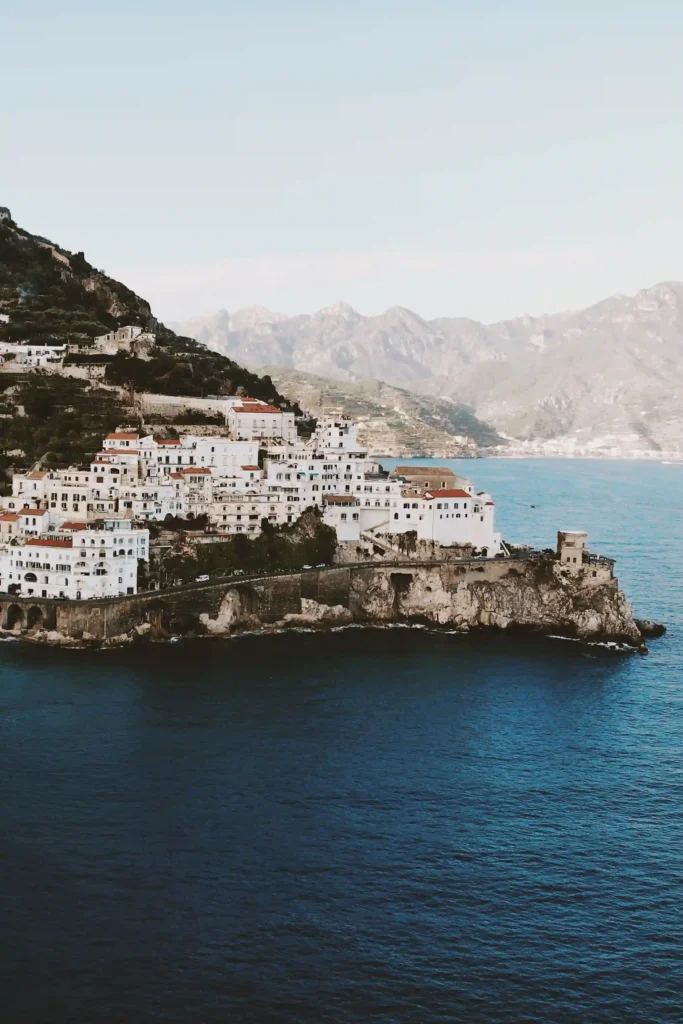 Den fantastiske kystlinjen i Amalfi, Italia, med pittoreske hvite bygninger mot det blå havet – et drømmested for et destinasjonsbryllup. Fotografert av Anna O. Brambilla. The stunning coastline of Amalfi, Italy, featuring picturesque white buildings against the blue sea, a dreamy setting for a destination wedding. Captured by Anna O. Brambilla.