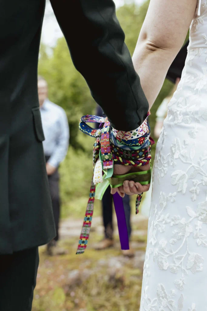 Seremonibånd i bruk under intimt bryllup i Norge – fotografert av Anna O. Brambilla Colorful ceremonial ribbons – handfasting at an intimate wedding in Norway – photographed by Anna O. Brambilla