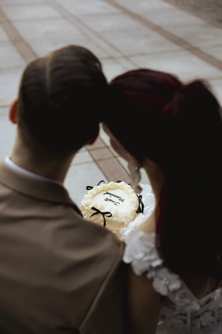 “Couple sitting close together, holding a small ‘Just Married’ cake during their intimate city elopement in Oslo — photographed by Anna O. Brambilla, wedding photographer.” “Brudepar som sitter tett sammen og holder en liten ‘Just Married’-kake under sitt intime elopement i Oslo — fotografert av Anna O. Brambilla, bryllupsfotograf.”