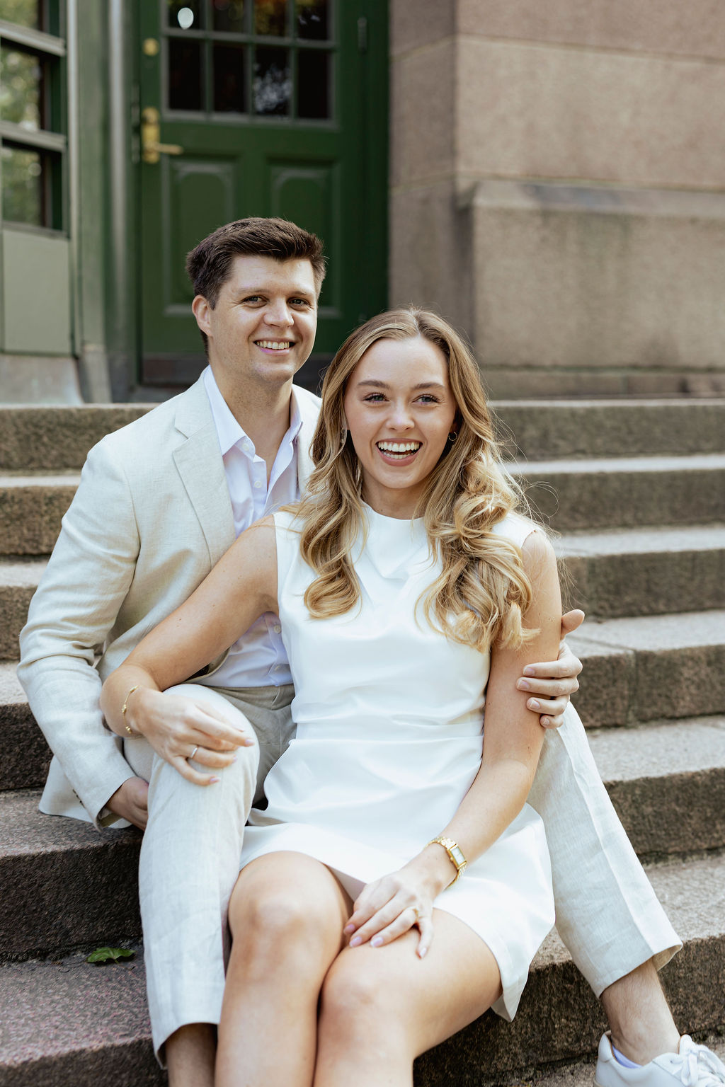 Forlovelsesfotografering i Oslo – nærbilde av Malene og Edvard som ler sammen på trappen ved Botanisk Hage. Bildet av bryllupsfotograf Anna O. Brambilla