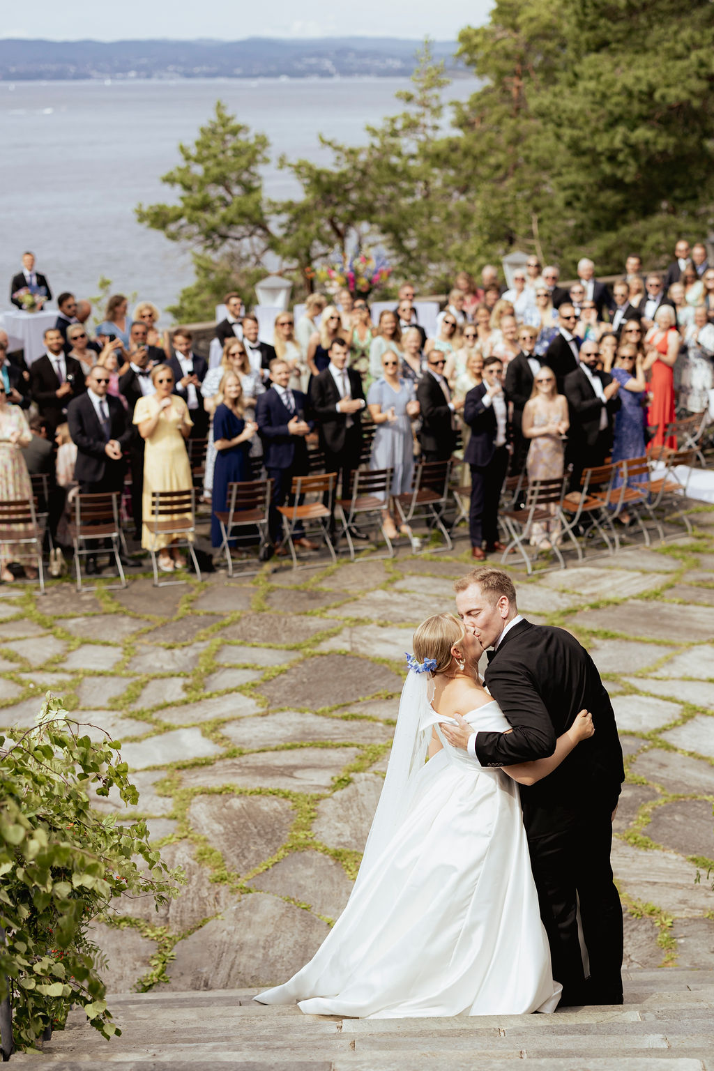 Brudepar kysser etter vielse foran gjester på Ingierstrand Bad Restaurant i Oslo