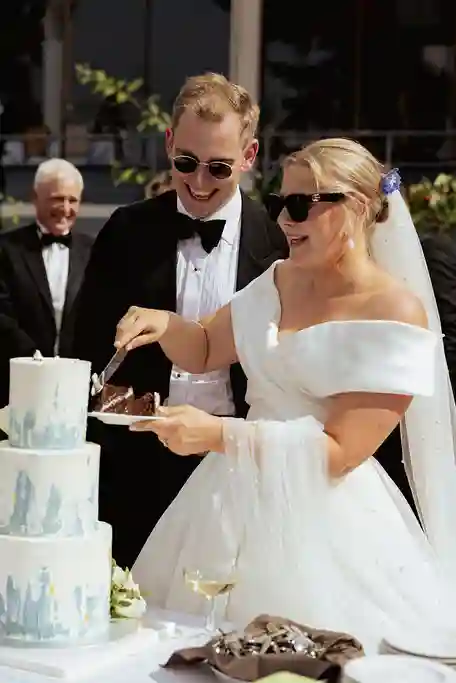 Brudepar skjærer bryllupskake utendørs på Ingierstrand Bad Restaurant