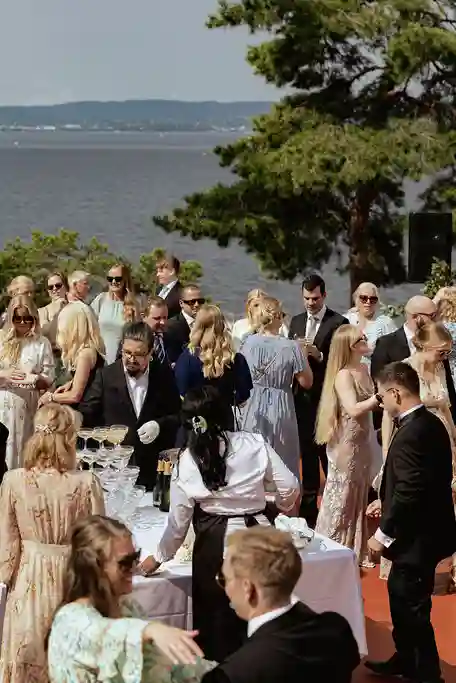 Bryllupsgjester mingler utendørs ved sjøen på Ingierstrand Bad Restaurant