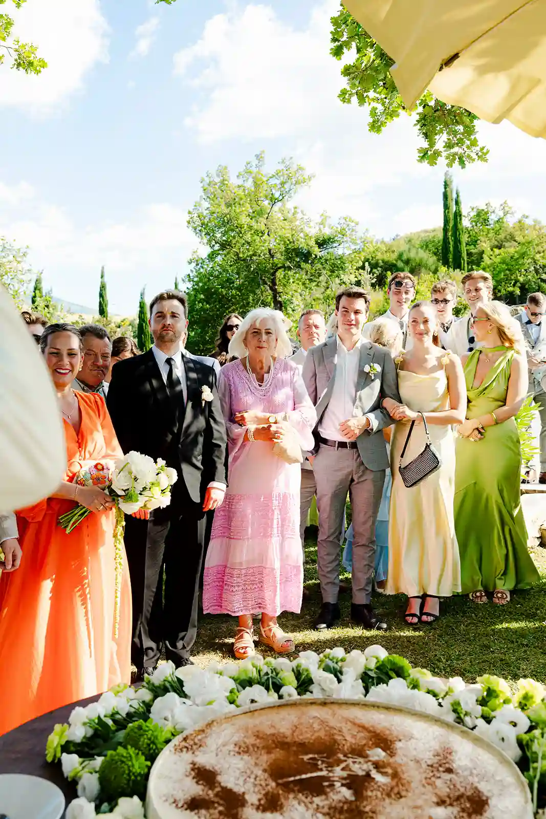 Brudepar og gjester samlet til gruppebilde etter vielsen i Toscana Bride and groom with their guests gathered for a group photo after the ceremony in Tuscany