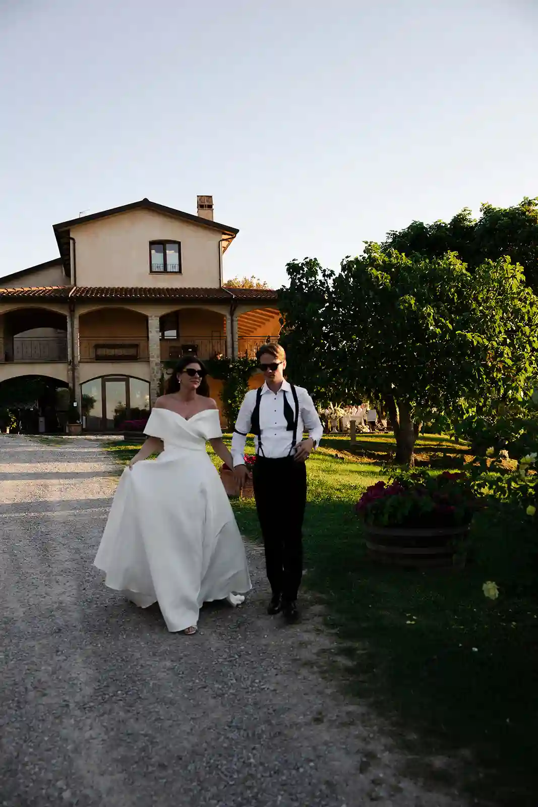 Brudeparet går ut sammen for portretter i kveldssolen under bryllupet i Toscana Bride and groom walking out together for portraits in the evening light during their Tuscany wedding