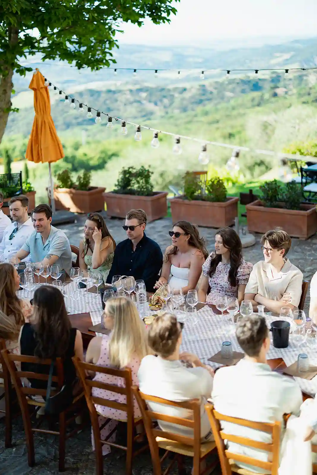 Brudepar og gjester samlet rundt bordet under velkomstfesten i Toscana Bride and groom with their guests around the table during their welcome party in Tuscany