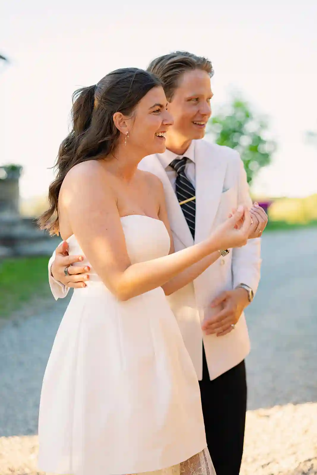 Brudepar ler sammen under pizzakvelden før bryllupet i Toscana Bride and groom laughing together during their pre-wedding pizza party in Tuscany