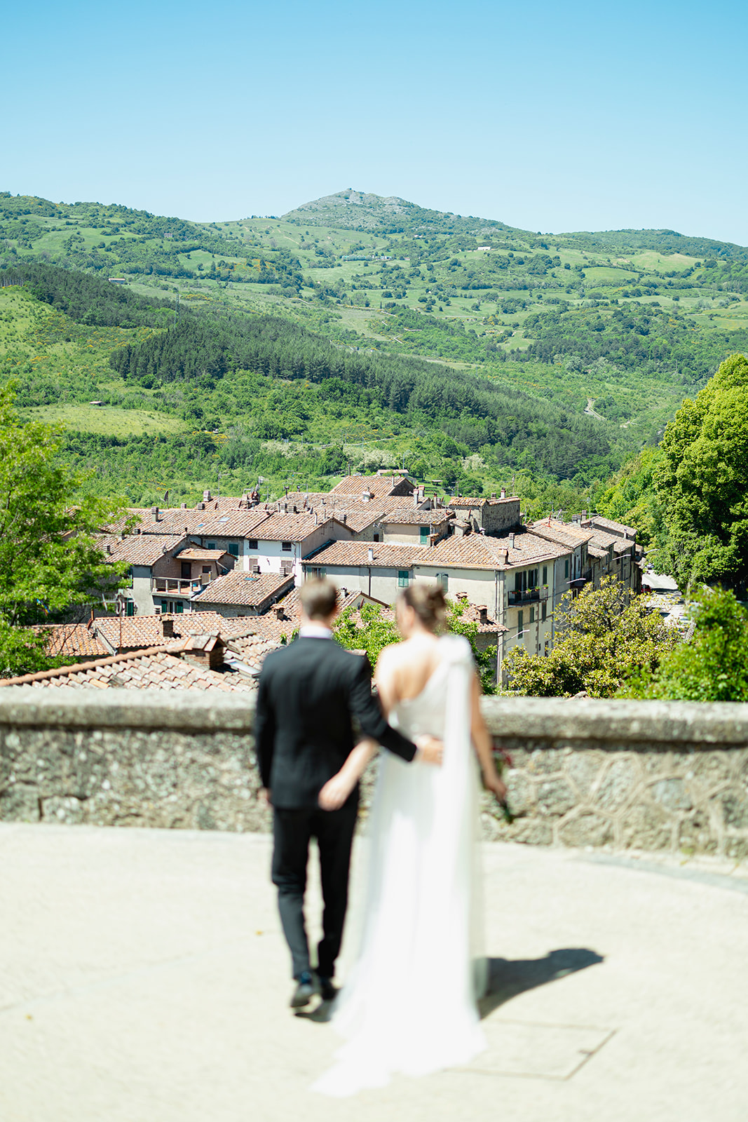Brudepar med utsikt over Santa Fiora og det grønne landskapet på Monte Amiata Newlyweds overlooking Santa Fiora and the green landscape of Monte Amiata